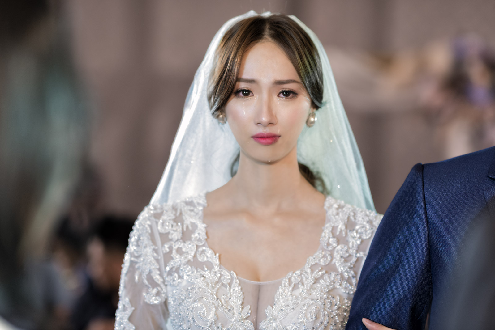 婚禮現場新娘含淚凝視鏡頭,情緒飽滿、畫面凝重
