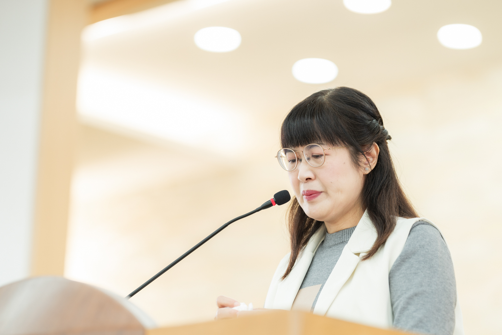 女性講者在舞台上發表演說,臉部補光自然清晰