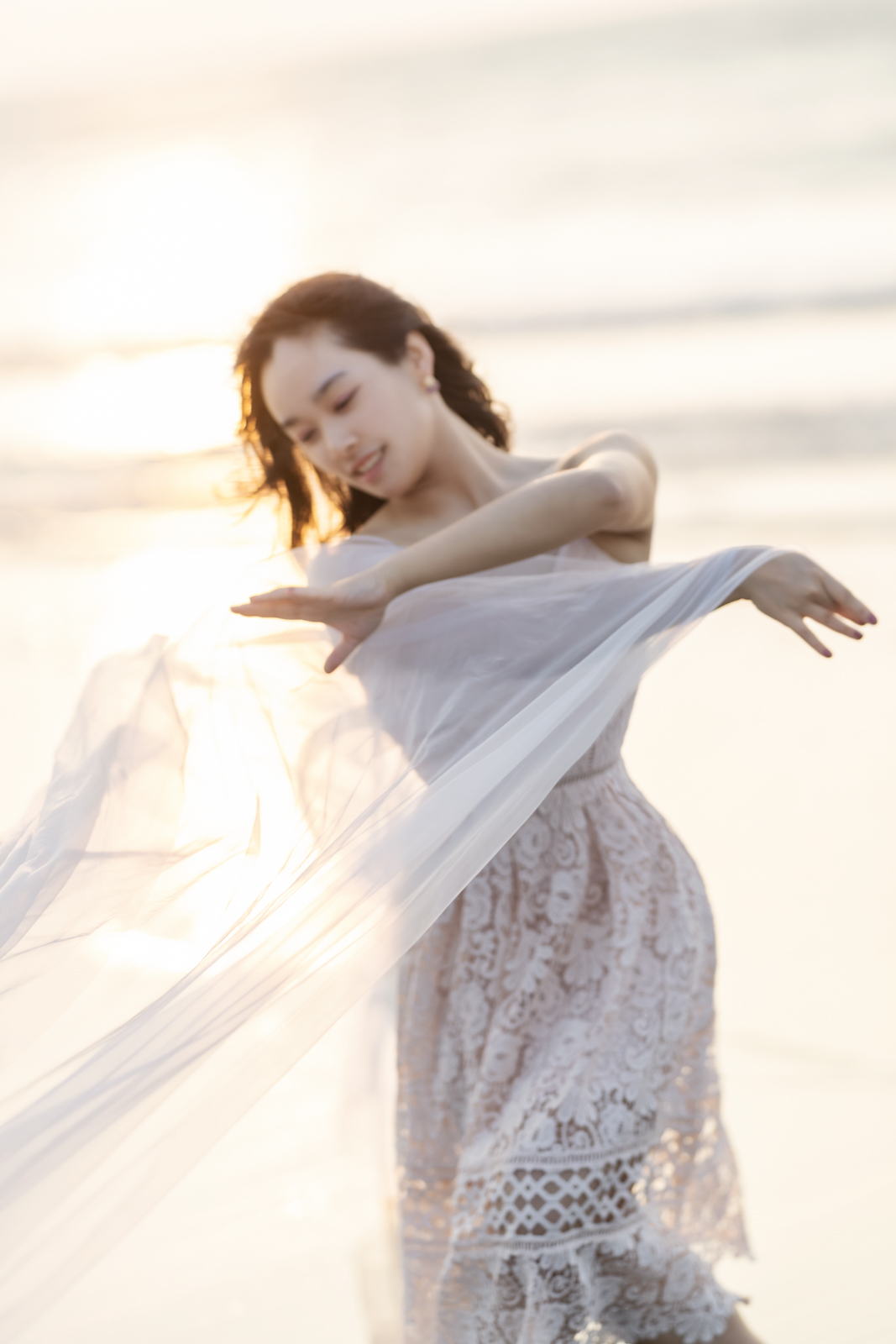 模特兒在海灘夕陽下舞動白紗特寫