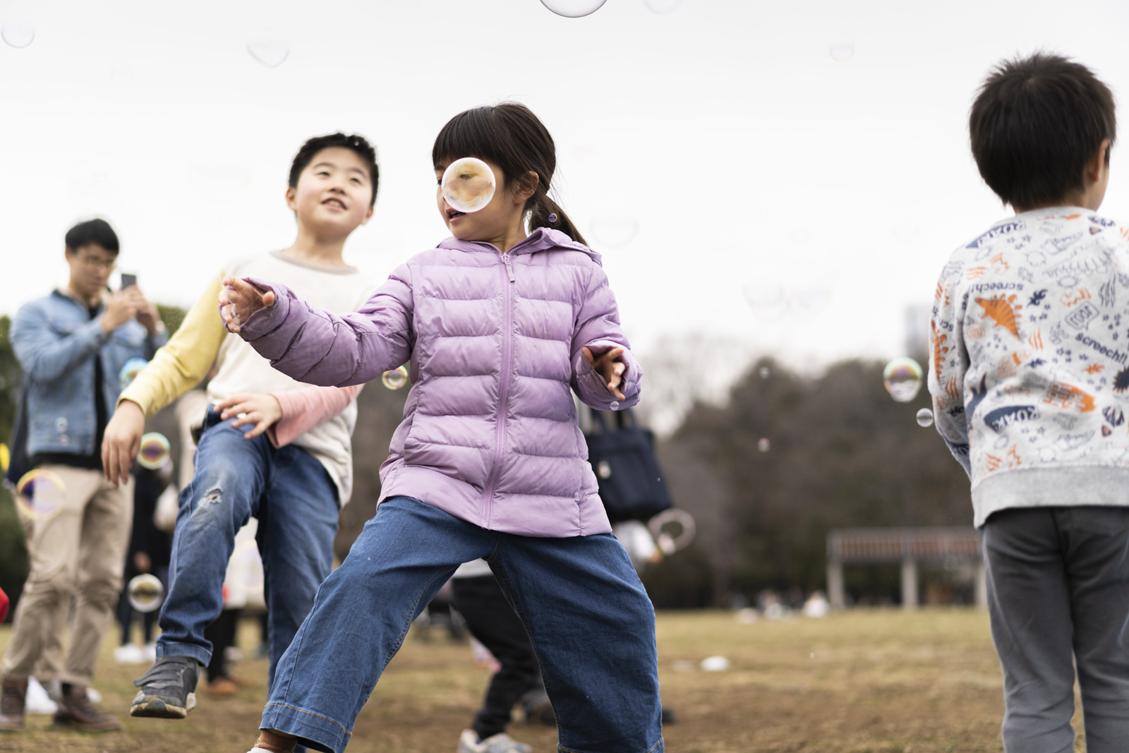 公園裡小孩奔跑追逐泡泡的瞬間