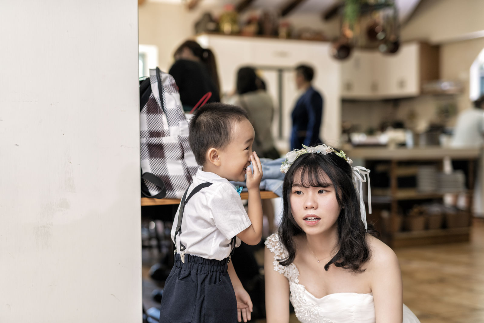 小朋友在室內對伴娘耳語,伴娘表情驚訝