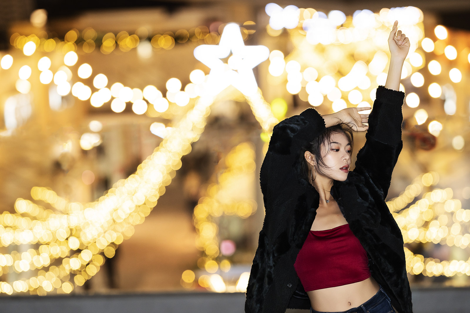 女孩在燈海前舞動身體
