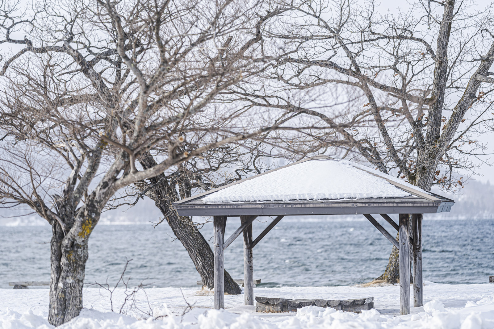冬季湖邊的木造涼亭與雪景