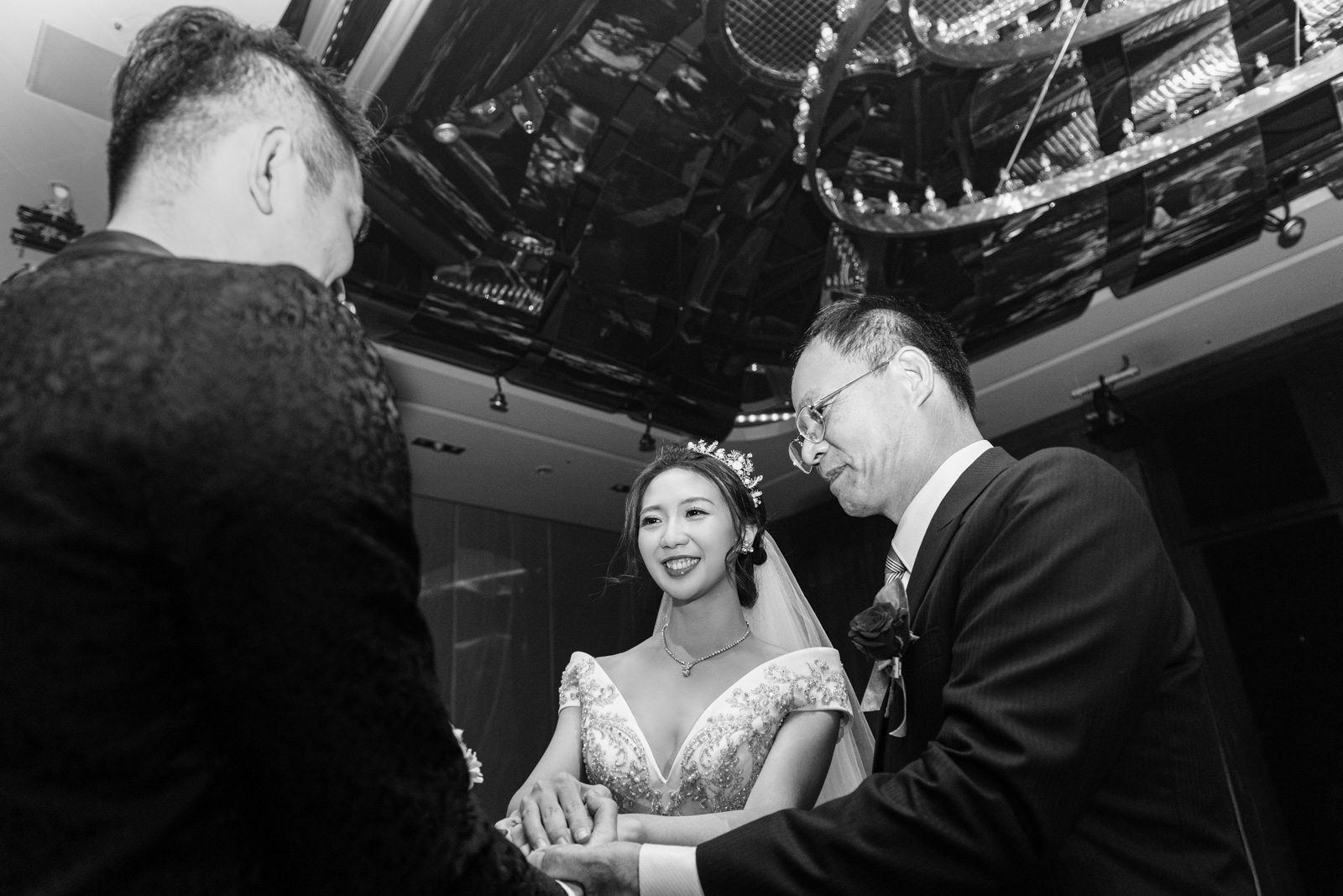 婚禮交手儀式中，新娘牽著父親與新郎雙手