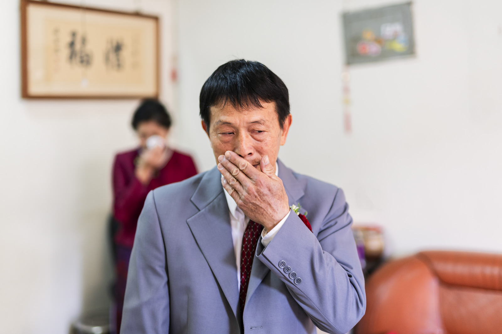 新娘父親情緒激動掩面落淚,母親站在後方默默拭淚