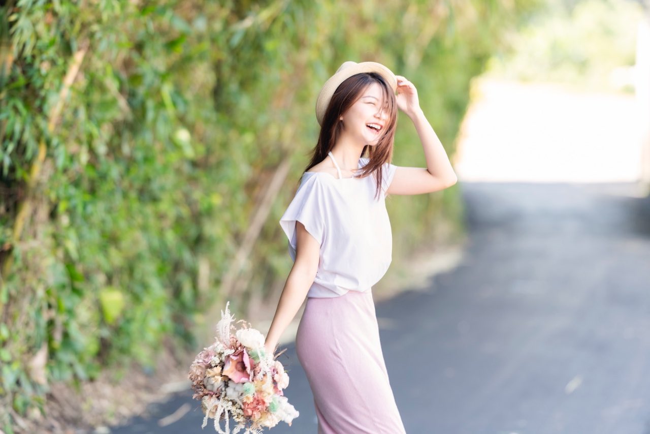 女子站在竹林小道上笑容燦爛