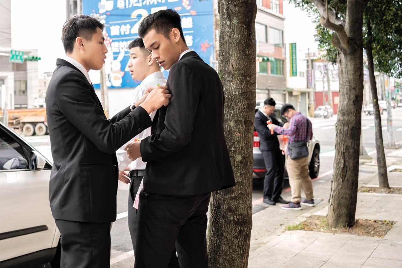 伴郎幫彼此整理胸花站在街頭