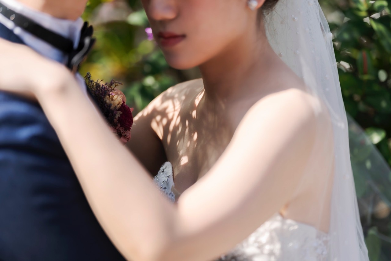 婚禮現場中,新娘靠在新郎胸前,畫面柔焦感強烈