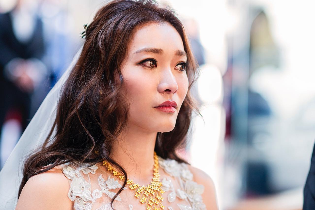 新娘跪拜父親時含著淚聆聽叮嚀，眼神哽咽而堅定