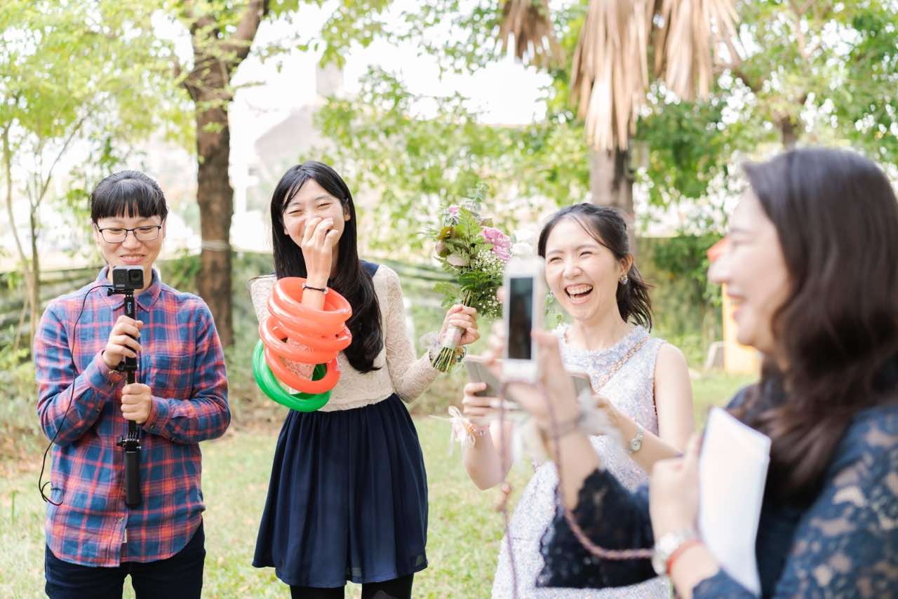 四位伴娘在戶外歡笑、直播、拿道具