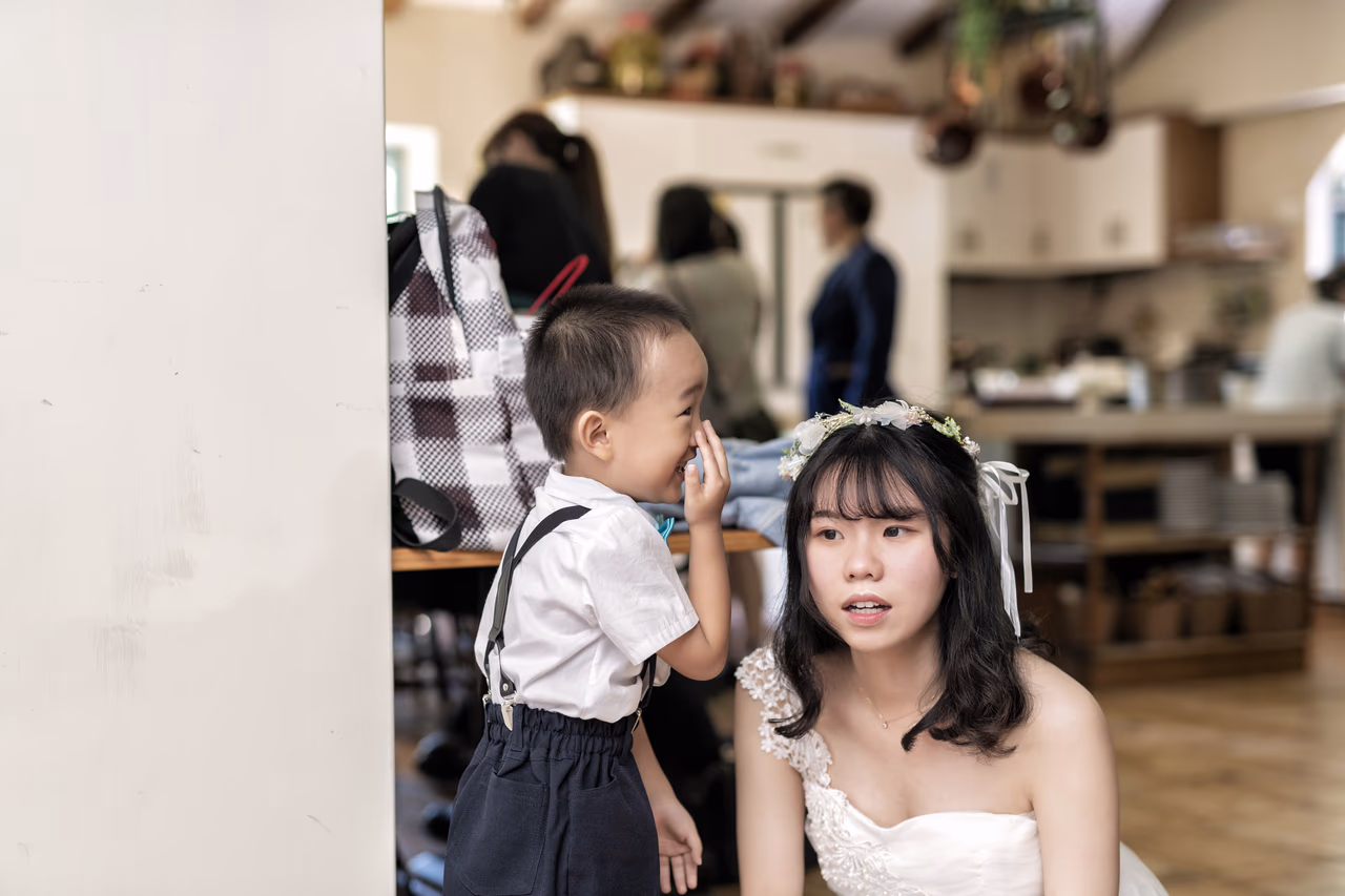 小朋友在室內對伴娘耳語，伴娘表情驚訝