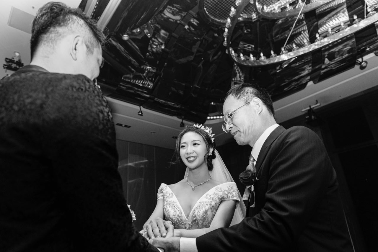 婚禮交手儀式中,新娘牽著父親與新郎雙手