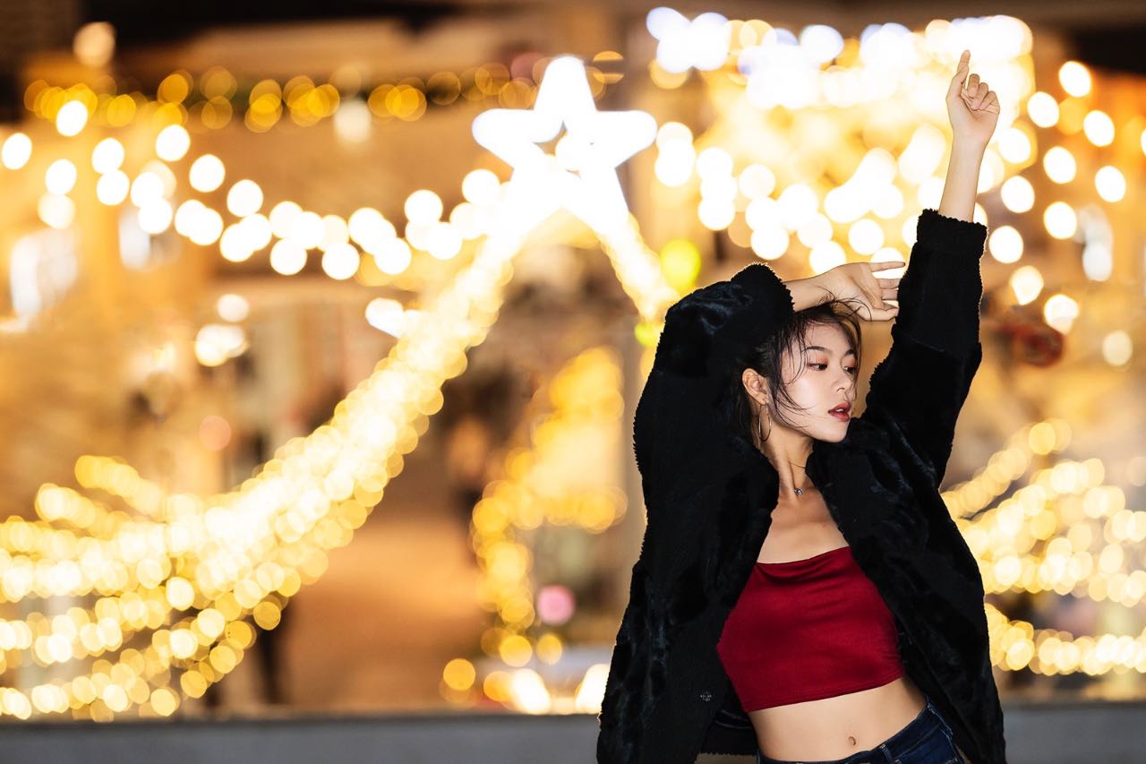 女孩在燈海前舞動身體