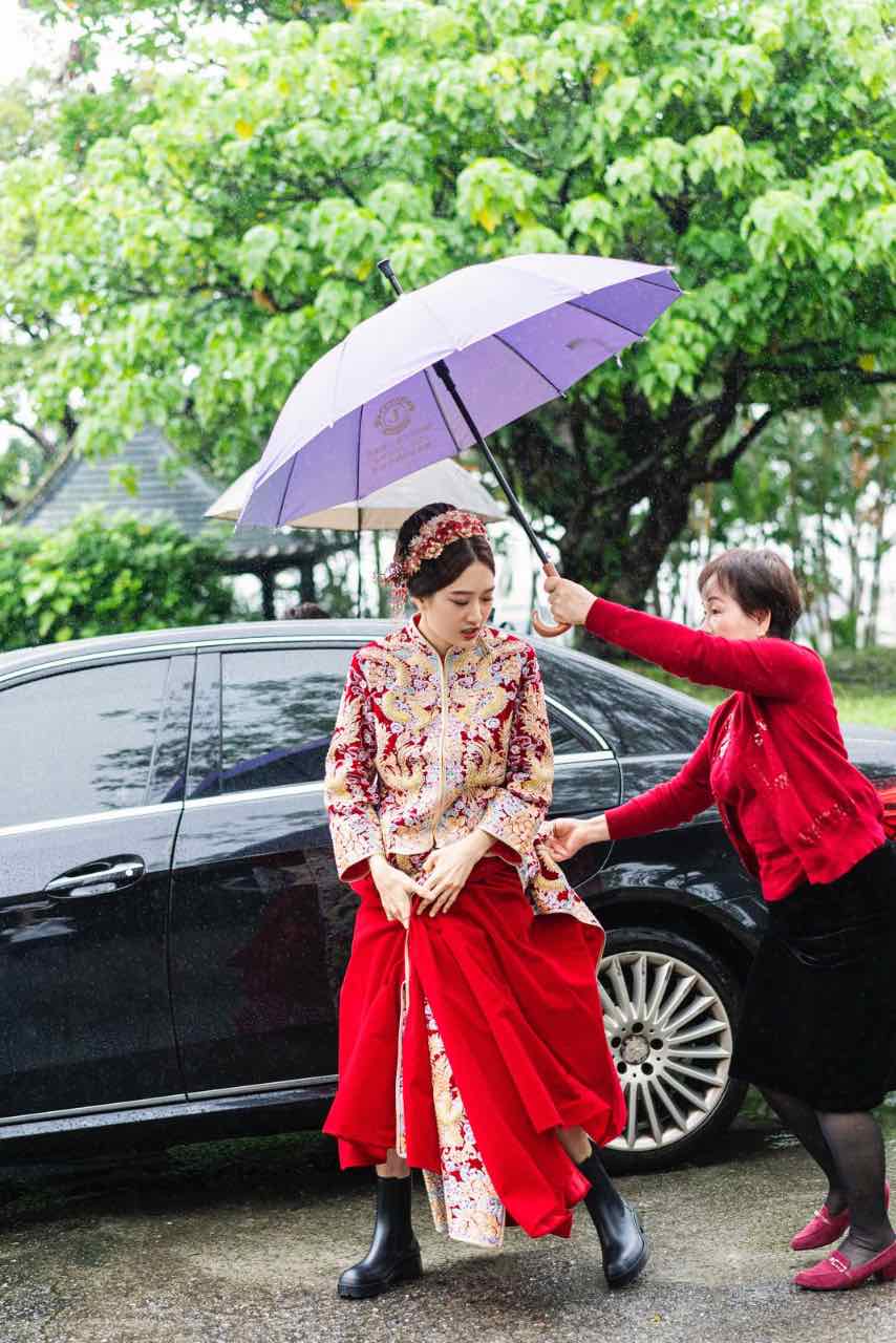 新娘著紅色中式婚禮服裝與雨鞋行走