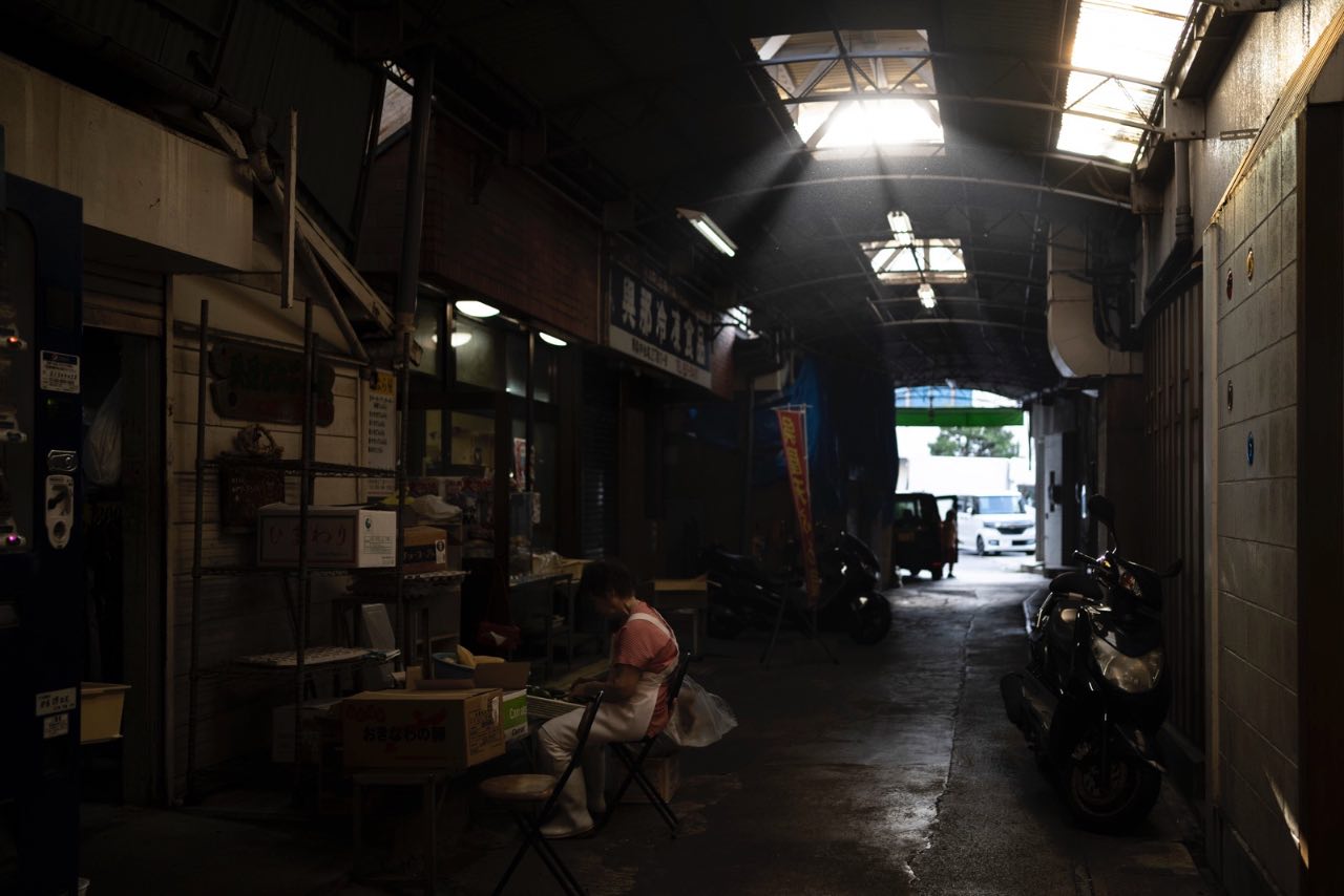 沖繩市場街拍 坐著剝菜的婦人 光束 灰塵