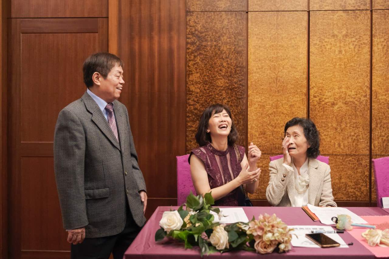 婚禮簽到桌前家人互動談笑,笑聲與眼神都充滿溫度