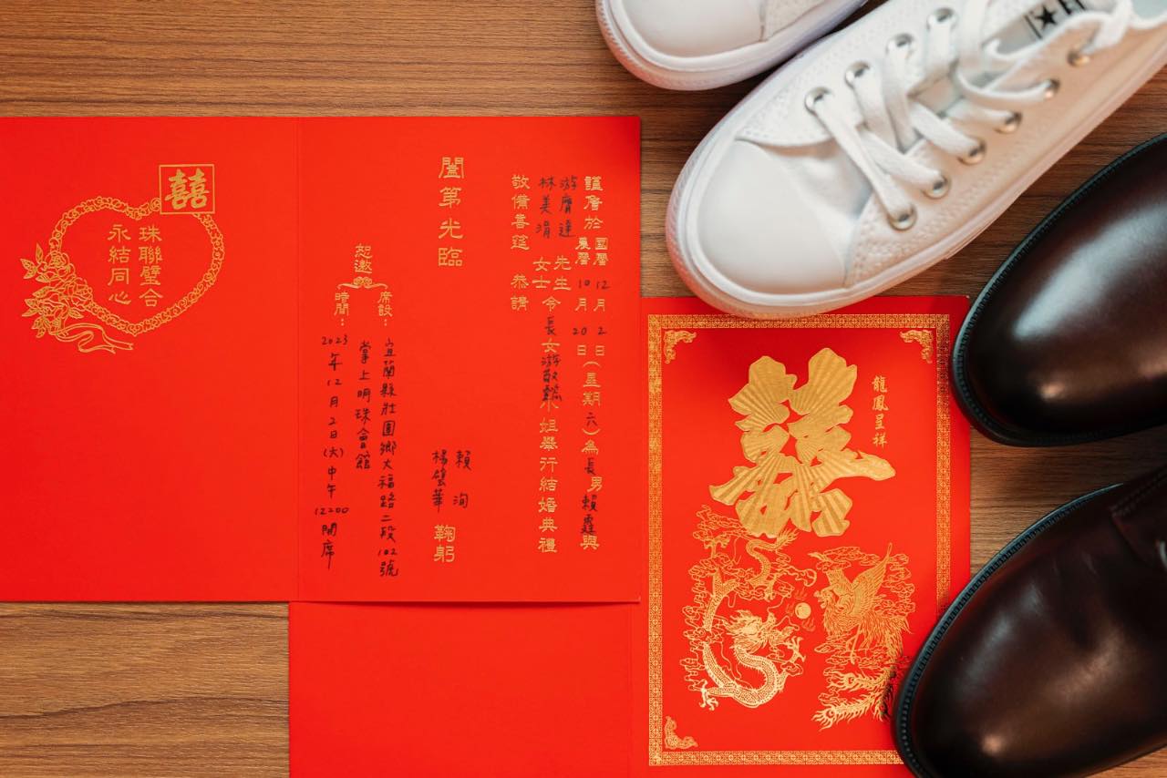 婚禮喜帖與白鞋黑鞋並排放置