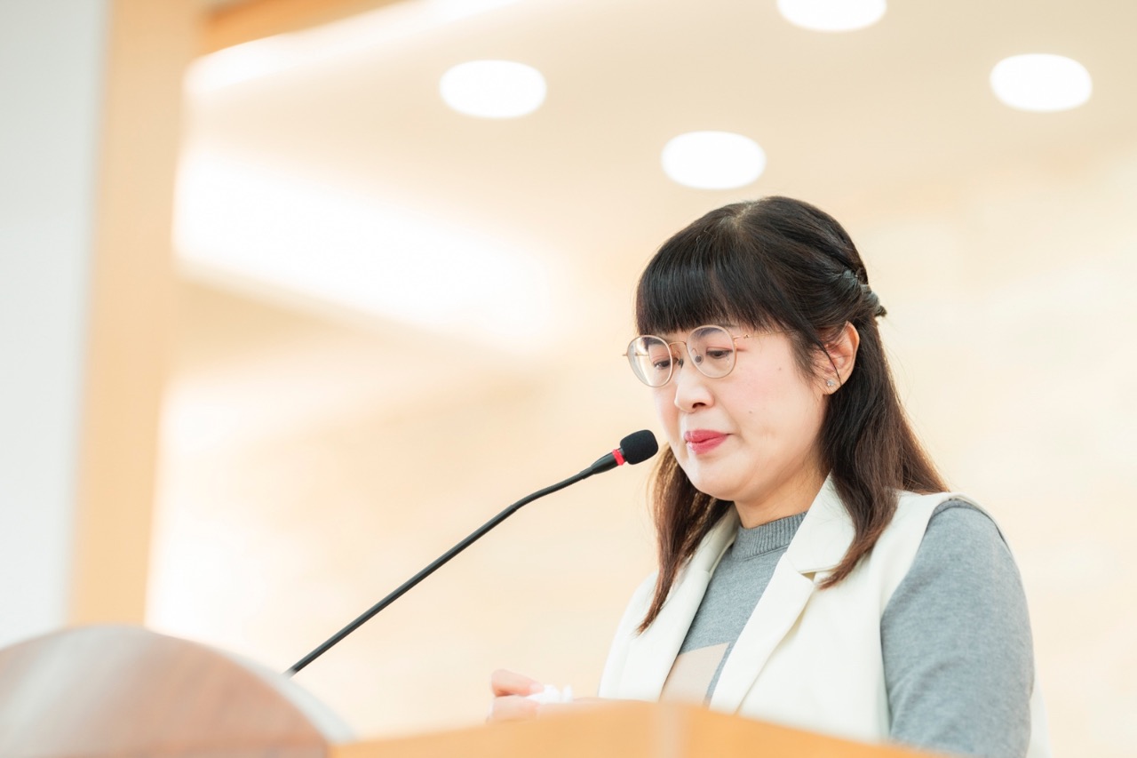 女性講者在舞台上發表演說,臉部補光自然清晰