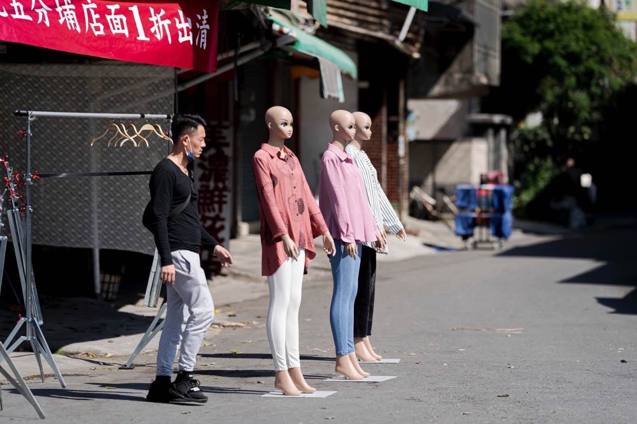 市場前站立的人與三座人形模特