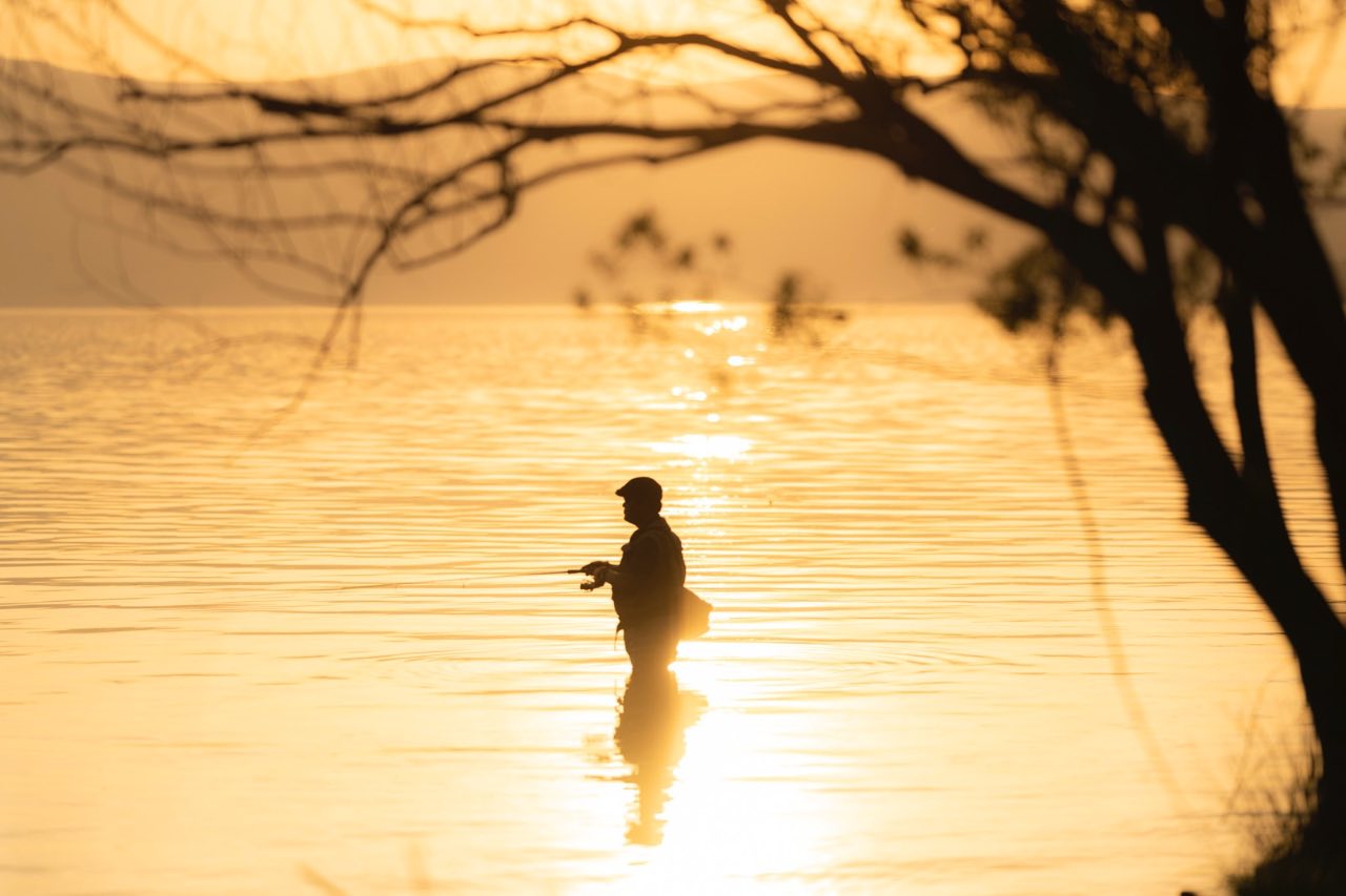 屈斜路湖黃昏釣魚者剪影與夕陽倒影