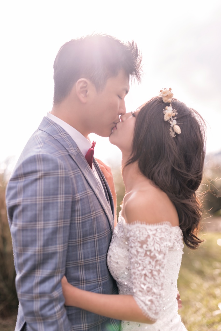 在陽明山黃昏時分拍攝的婚紗照,霧氣瀰漫的逆光裡,新人深情親吻,氛圍唯美浪漫。