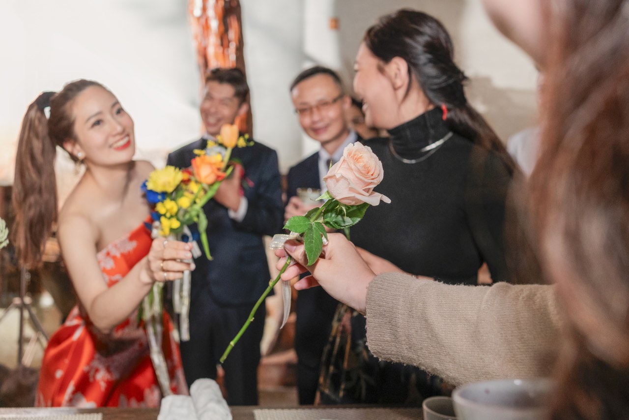新娘遞出花束與親友交換笑容的畫面